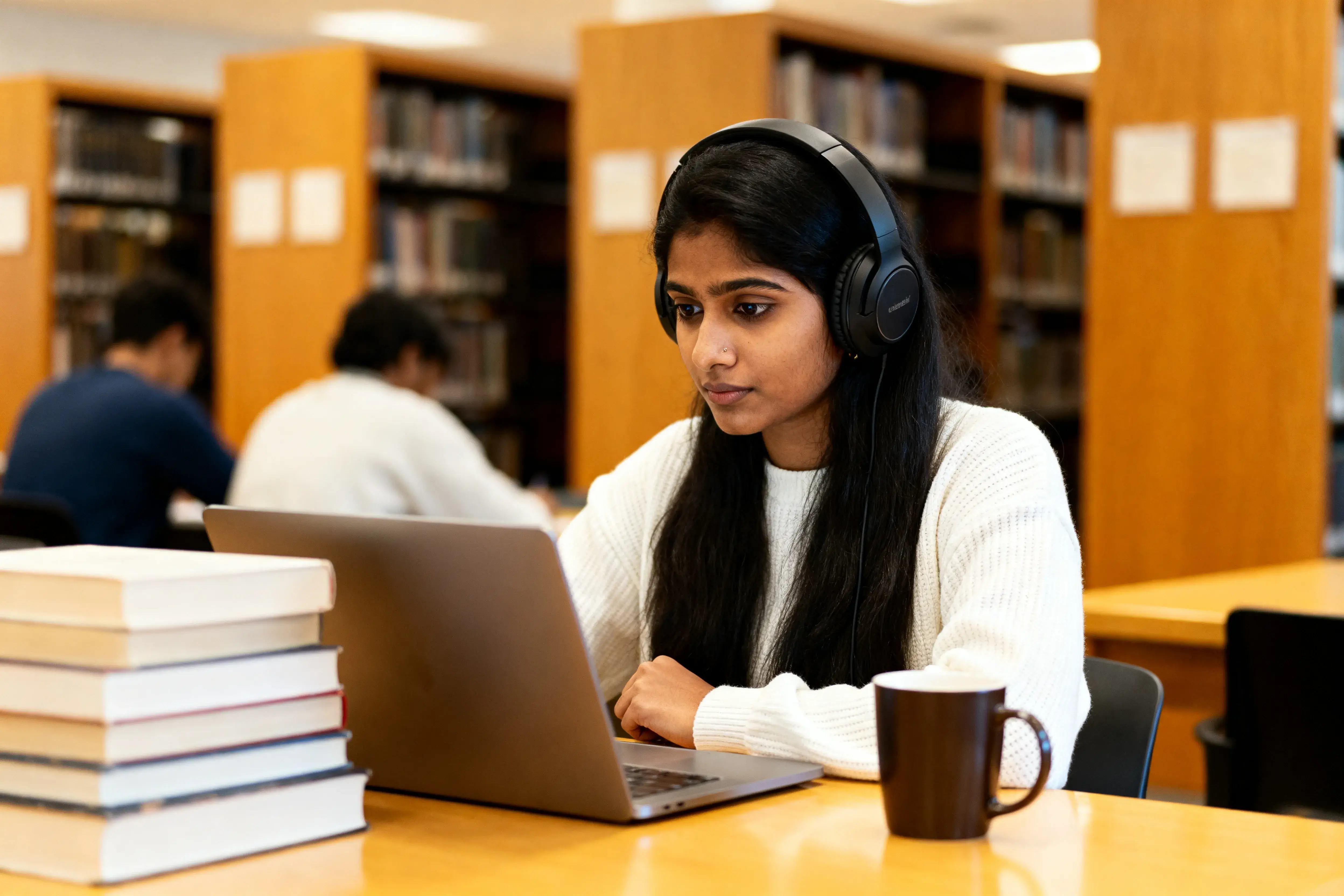 Student studying with headphones at library